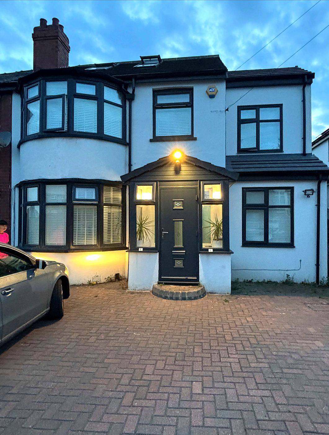 Finished house with dark resprayed windows and door at dusk