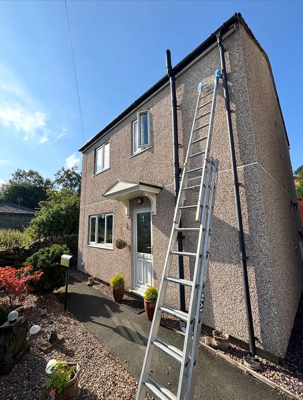 Detached house with masonry walls sprayed in Plymouth Grey using an airless sprayer