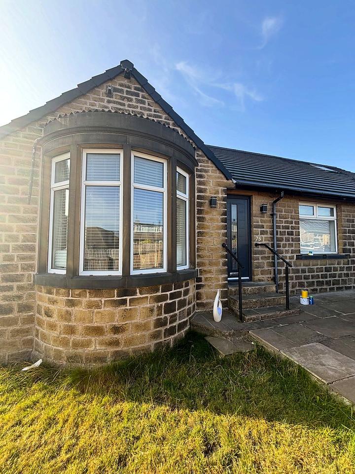 Stone bungalow bay window in a dark finish